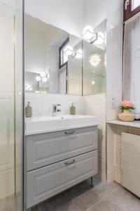 ein weißes Badezimmer mit einem Waschbecken und einem Spiegel in der Unterkunft Luxury Apartment With Balcony next to the New York Café in Budapest