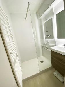 uma casa de banho branca com um chuveiro e um lavatório. em Exclusivité, 6Pers, Sauna, wifi, local à ski em Isola 2000