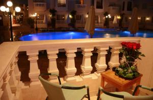 een balkon met een tafel en stoelen en een zwembad bij Oriental Rivoli Hotel & Spa in Sharm El Sheikh