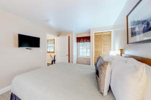 a bedroom with a bed and a tv on the wall at Northwoods Lodge Cabin 1 in Morrisville