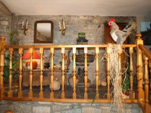 un gallo sentado sobre una barandilla de madera en Casa Piquero, en Sieste
