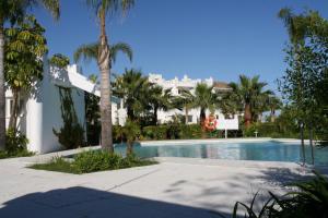 una piscina con palmeras y un edificio en 2152-Modern apt with private beach, en Estepona