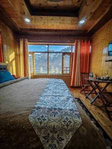 a bedroom with a large bed and a large window at The Alpinist cafe and Retreat in Kaza