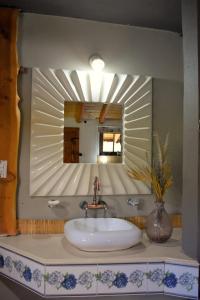 a bathroom with a sink and a mirror at Cabañas La Oma Intiyaco in Atos Pampa