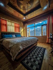 a bedroom with a large bed with a mountain view at The Alpinist cafe and Retreat in Kaza