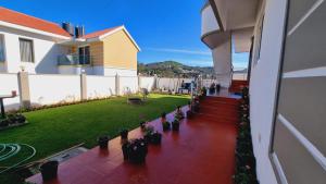 uma varanda de um edifício com um quintal com vasos de plantas em SAIBALA RESlDENCY - NEAR BOAT HOUSE em Ooty