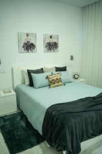 1 dormitorio con 1 cama grande y 2 cuadros en la pared en Majestic Seaview Villa, en Fajã da Ovelha