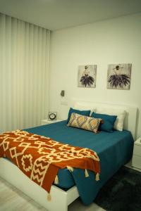 1 dormitorio con 1 cama con edredón azul en Majestic Seaview Villa, en Fajã da Ovelha