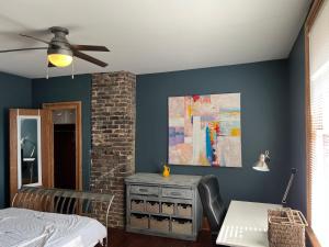 a bedroom with blue walls and a ceiling fan at Uptown Treehouse in New Orleans
