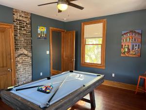 a pool table in a room with a ceiling fan at Uptown Treehouse in New Orleans