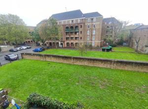 un ampio cortile verde di fronte a un edificio di 2 BEDROOM FLAT NEXT TO ARSENAL STADIUM - HIGHBURY a Londra