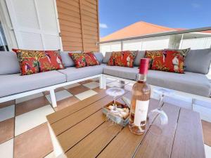 Una botella de vino sentada en una mesa en un patio en Villa Caribbean Star, 5 min walk from the beach en Orient Bay