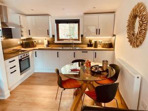 a kitchen with a table and chairs and a sink at Stag's Hide in Aviemore