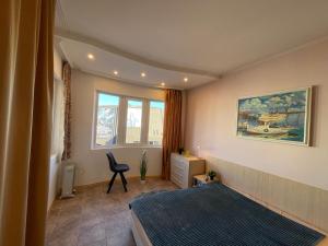 a bedroom with a bed and a desk and a window at Varna apartment in Varna City