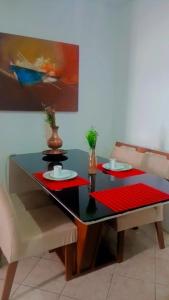a dining room table with two plates and two chairs at Serra Negra - Melhor localização da cidade in Serra Negra