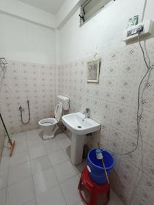 a bathroom with a toilet and a sink at Manipur House in Imphal