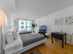 迈阿密Cozy and Bohemian Studio in Brickell的一间卧室，配有一张床、一张书桌和一台电视