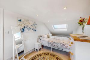 um pequeno quarto com uma cama e um espelho em Beautiful two bedroom apartment in Honor Oak em Londres