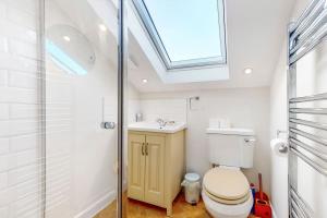 a bathroom with a toilet and a sink and a skylight at Beautiful two bedroom apartment in Honor Oak in London