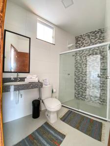 a bathroom with a toilet and a glass shower at Villa do Mar in Cayru