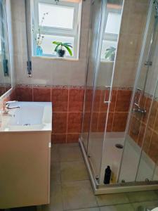 uma casa de banho com um chuveiro e um lavatório. em Our Little House em Vila Real de Santo António