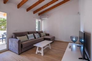 uma sala de estar com um sofá e uma mesa em Villa Sol del Sur 15 em Son Xoriguer