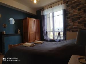 ein Schlafzimmer mit einem Bett und einem Fenster mit Handtüchern darauf in der Unterkunft Le gîte de l'écluse in Marolles-sous-Lignières