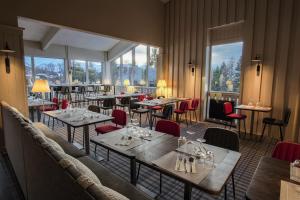 a restaurant with tables and chairs and windows at Belambra Clubs Arc 1800 - Hôtel Du Golf in Arc 1800