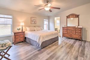 a bedroom with a bed and a dresser and a mirror at Eufaula Escape with Deck - Steps to Lake! in Eufaula