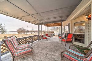a porch with chairs and a fireplace on a house at Eufaula Escape with Deck - Steps to Lake! in Eufaula