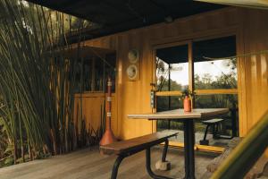 a wooden porch with a table and a bench at Redwood Salento in Salento