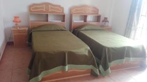 - 2 lits avec des couvertures vertes dans une chambre dans l'établissement Dodo Villa, à Pointe aux Biches