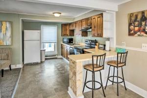 een keuken met een koelkast en 2 barkrukken bij Saratoga Springs Apartment half Mi to Downtown in Saratoga Springs
