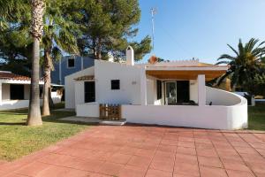 松霍里吉爾的住宿－Casa Sol del Sur 4，一座棕榈树掩映的白色房子
