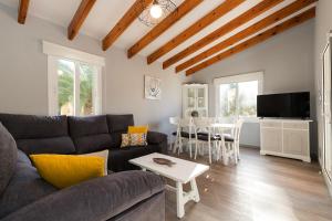 ein Wohnzimmer mit einem Sofa und einem Tisch in der Unterkunft Casa Sol del Sur 4 in Son Xoriguer
