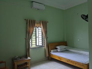 a bedroom with a bed and a window at nhà nghỉ Ngọc Lam in Quang Ba