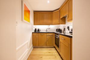 cocina con armarios de madera y suelo de madera en Hausd Flex - Covent Garden, en Londres