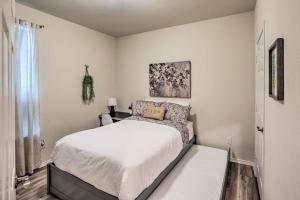 a bedroom with a large bed with white sheets at Sleek Fort Worth Home with Covered Patio! in Fort Worth