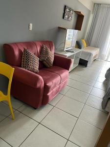 a living room with a red couch and a table at Terrazzo PontaNegra flat Flat Vista Mar Apto 201 in Natal