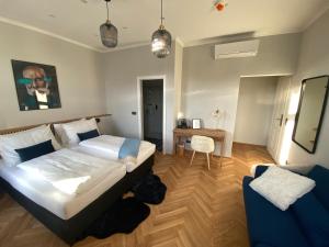 a bedroom with a bed and a table and a chair at Boutique Hotel Kolbeck in Vienna