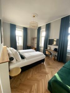 a bedroom with a large white bed and blue curtains at Boutique Hotel Kolbeck in Vienna