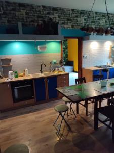 a kitchen with a table and a kitchen with blue lights at Pokoje pracownicze Witkowska in Gniezno