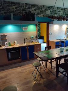 a kitchen with a table and a kitchen with blue lights at Pokoje pracownicze Witkowska in Gniezno