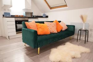 a green couch with colorful pillows in a living room at Peaceful Luxury Apartment in Croydon