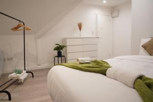 a bedroom with a bed with a green blanket on it at Peaceful Luxury Apartment in Croydon