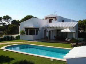 a house with a swimming pool in the yard at Villa Noray Cala Morell in Cala Morell