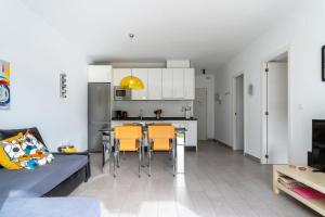 een woonkamer en een keuken met een tafel en stoelen bij Steps from Puerto Marina in Benalmádena