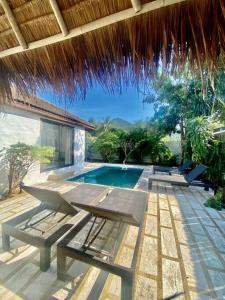 eine Terrasse mit einem Tisch, Stühlen und einem Pool in der Unterkunft Bamboo Villa in Ko Tao