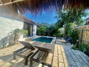 eine Terrasse mit einem Pool, einem Tisch und Stühlen in der Unterkunft Bamboo Villa in Ko Tao