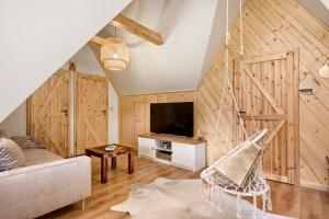 a living room with a couch and a tv at Apartamenty Kucovka 11 in Brzegi +69 photos